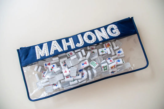 Navy top and lined clear bag with white letters and pearls spelling MAHJONG full of game pieces.