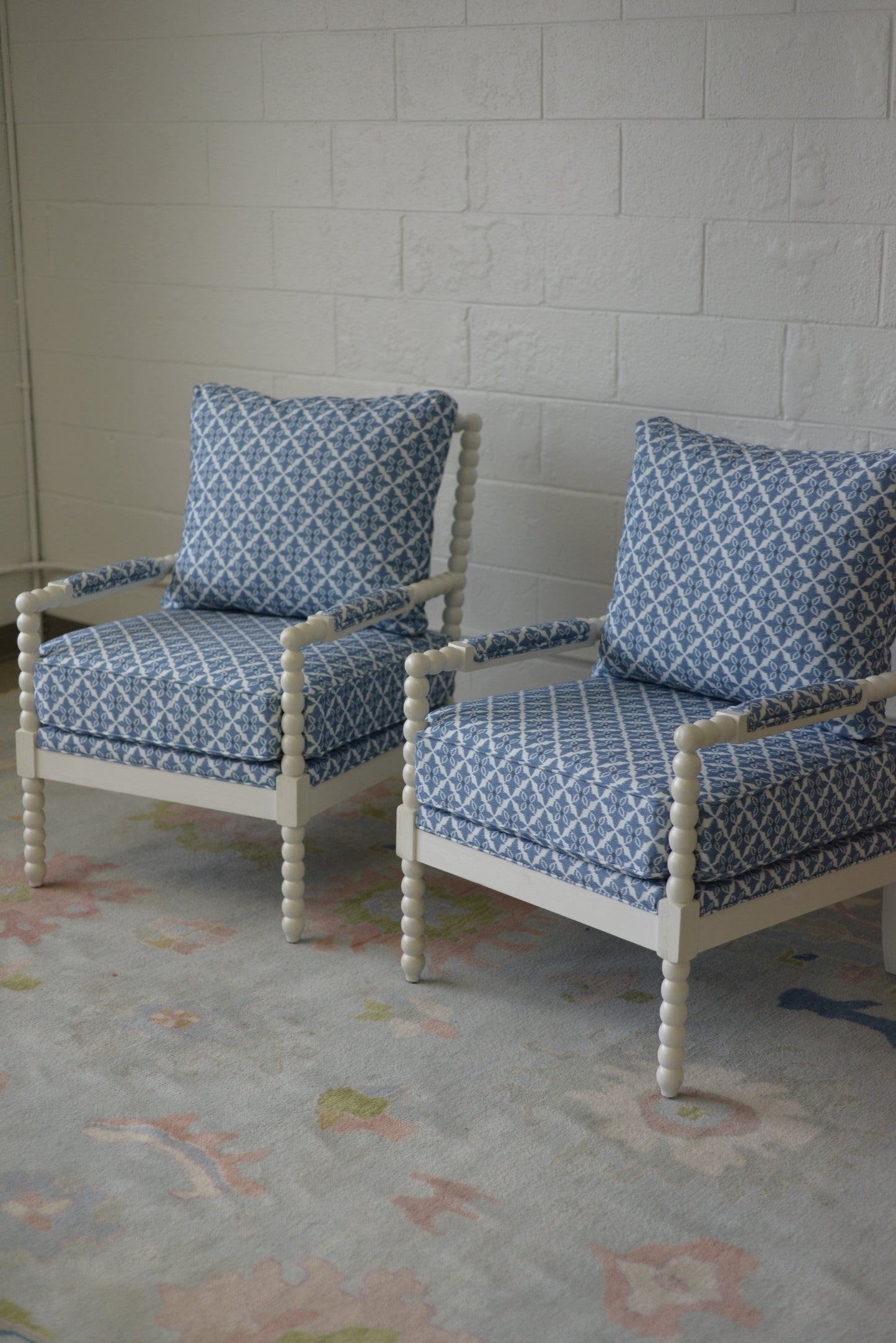 White spindle chair upholstered in blue and white fabric