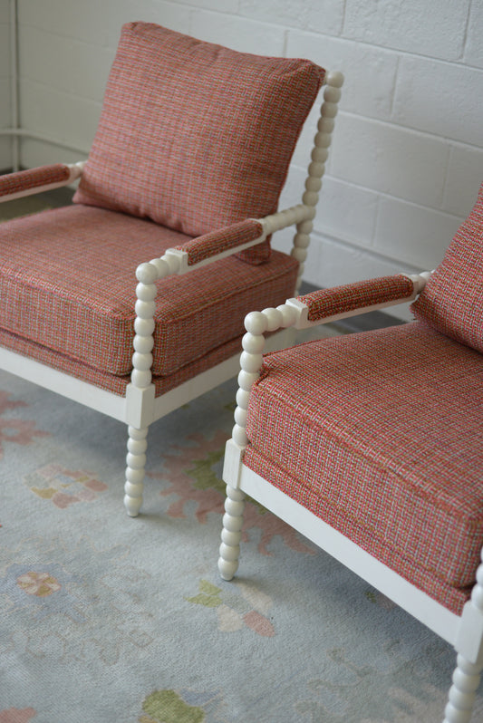 White spindle chair upholstered in pink and orange tweed fabric