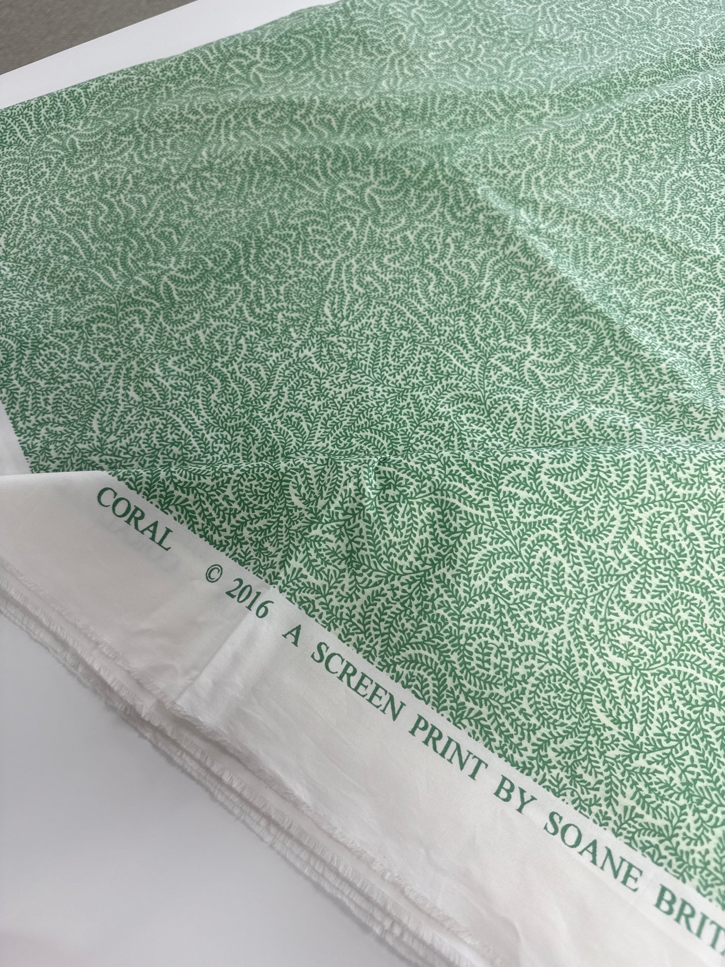 Soane Britain, coral, green, by the yard