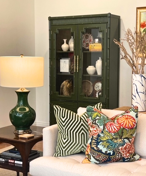 Furniture vignette of custom lacquered faux bamboo display cabinet painted in a deep olive green by Winston's Collection located in Winston Salem, NC shipping across the United States.